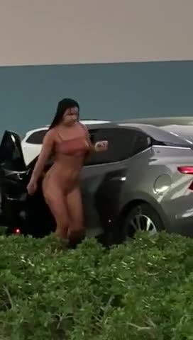 Une fille se change dans sa voiture