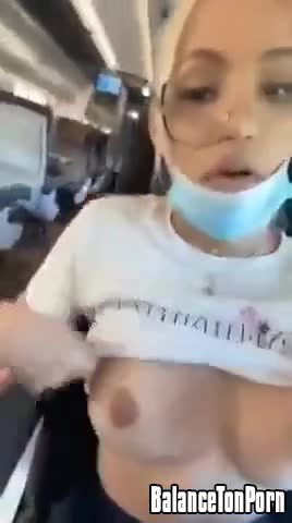 Une blonde montre ses seins dans l'avion